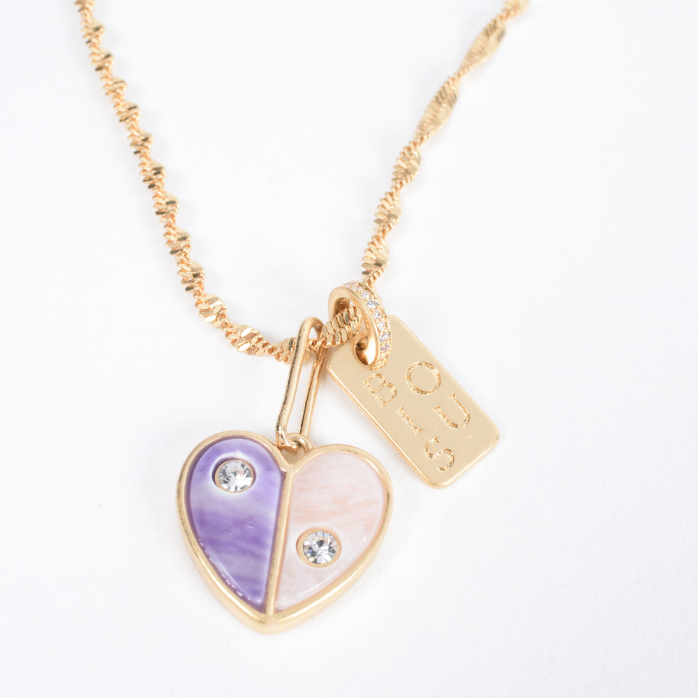 
                  
                    Embrace self-love with the Love Yourself Necklace, featuring a stunning two-tone heart crafted from brass with purple and pearl colored stone inlays. Each side of the heart is adorned with a sparkling zircon stone, symbolizing the balance between strength and tenderness. Paired with the matching Bisous bangle, this necklace is a reminder to cherish yourself and celebrate your unique journey. Designed for versatility, it can be worn alone or layered to inspire confidence and radiance in every version of you.
                  
                