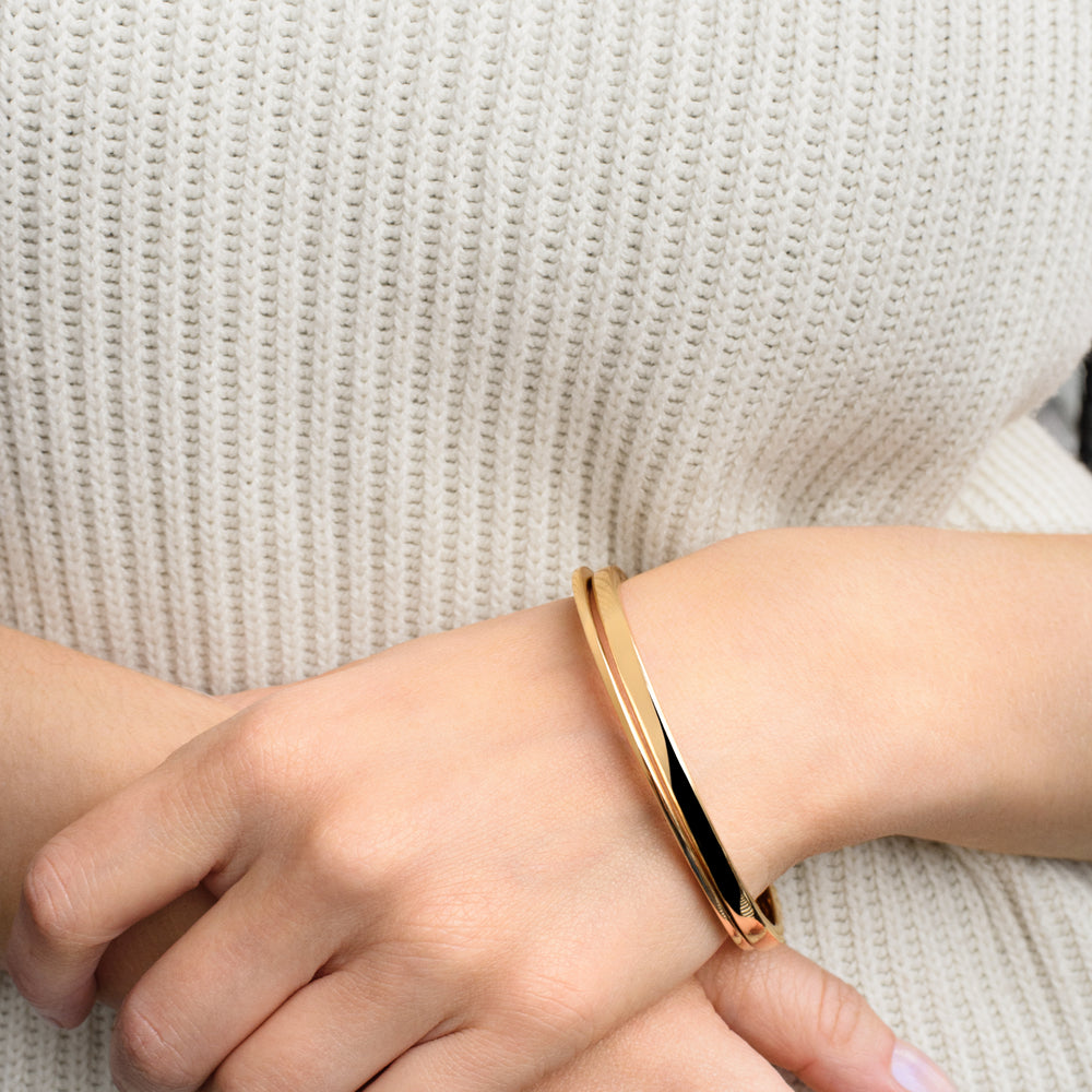 
                  
                    Close-up of the Everri Infinity Bangle worn by model, featuring a sleek, modern silhouette with a subtle twist, symbolizing continuity and personal growth.
                  
                