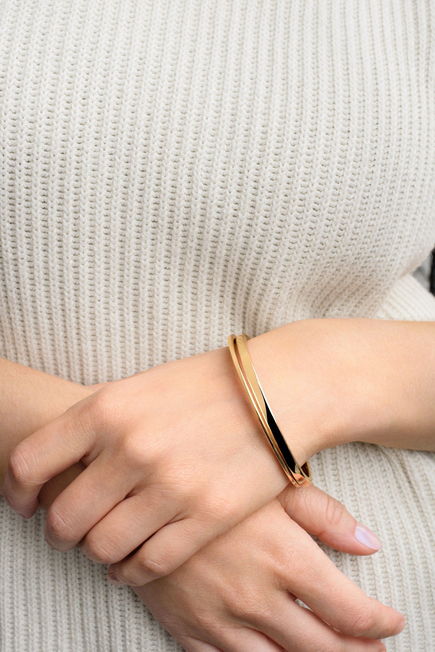 Close-up of the Everri Infinity Bangle worn by model, featuring a sleek, modern silhouette with a subtle twist, symbolizing continuity and personal growth.