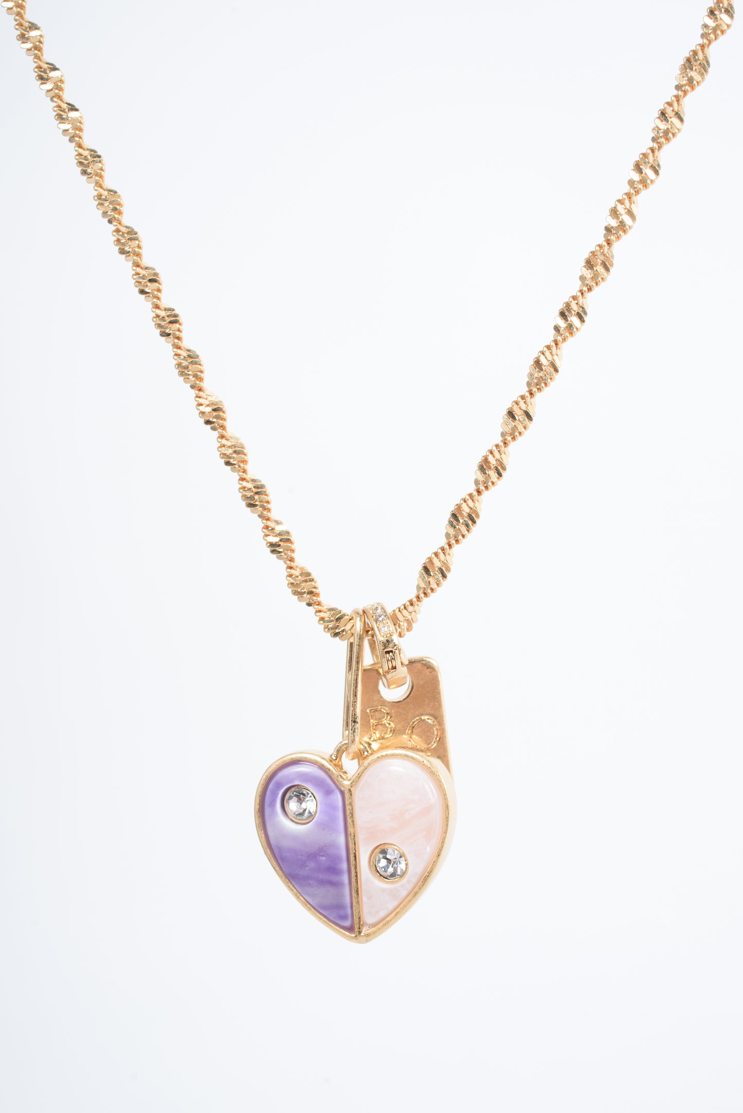 Embrace self-love with the Love Yourself Necklace, featuring a stunning two-tone heart crafted from brass with purple and pearl colored stone inlays. Each side of the heart is adorned with a sparkling zircon stone, symbolizing the balance between strength and tenderness. Paired with the matching Bisous bangle, this necklace is a reminder to cherish yourself and celebrate your unique journey. Designed for versatility, it can be worn alone or layered to inspire confidence and radiance in every version of you.