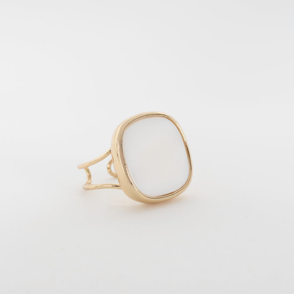 Close-up of the Solace Ring, featuring a white square signet with gently rounded corners and an open side and back design, offering a sleek, refined look and an embracing feel around the finger.