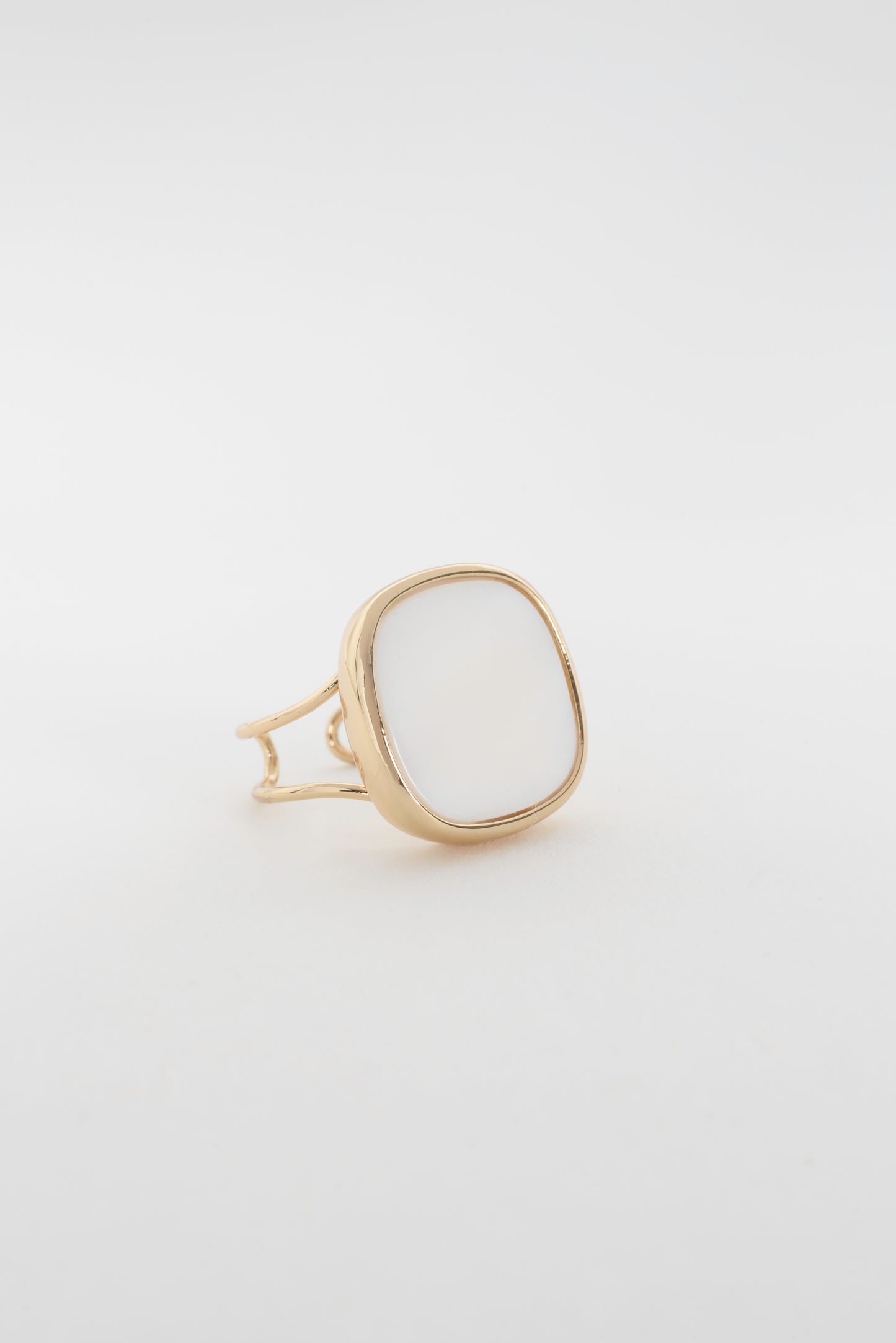 Close-up of the Solace Ring, featuring a white square signet with gently rounded corners and an open side and back design, offering a sleek, refined look and an embracing feel around the finger.